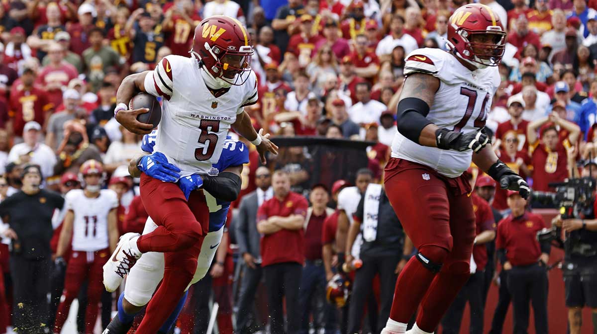 Washington Commanders quarterback Jayden Daniels (5) runs the ball as New York Giants linebacker Abdul Carter (51) defends during the second quarter at Northwest Stadium.