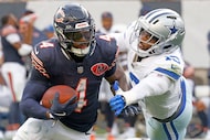 Chicago Bears running back d'Andre Swift (4) keeps the ball away from Dallas Cowboys...