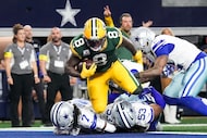Green Bay Packers running back Josh Jacobs (8) scores on a touchdown run past Dallas Cowboys...