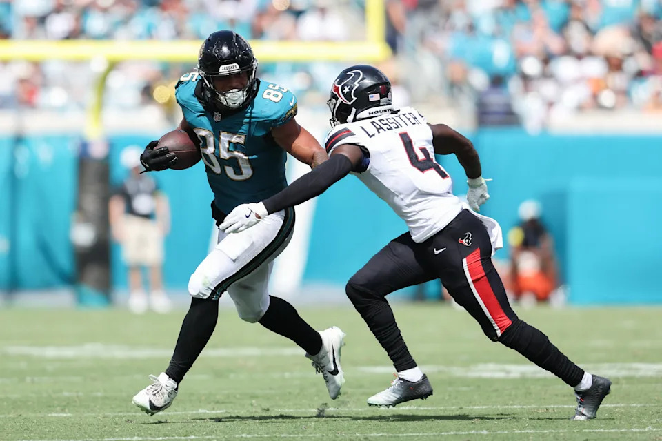 Sep 21, 2025; Jacksonville, Florida, USA; Jacksonville Jaguars tight end Brenton Strange (85) runs the ball against Houston Texans cornerback Kamari Lassiter (4) during the third quarter at EverBank Stadium. Mandatory Credit: Morgan Tencza-Imagn Images