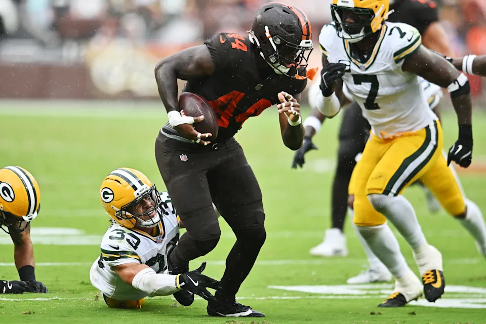 Sep 21, 2025; Cleveland, Ohio, USA; Green Bay Packers running back Emanuel Wilson (23) tries to tackle Cleveland Browns tight end Harold Fannin Jr. (44) during the second half at Huntington Bank Field. Mandatory Credit: Ken Blaze-Imagn Images