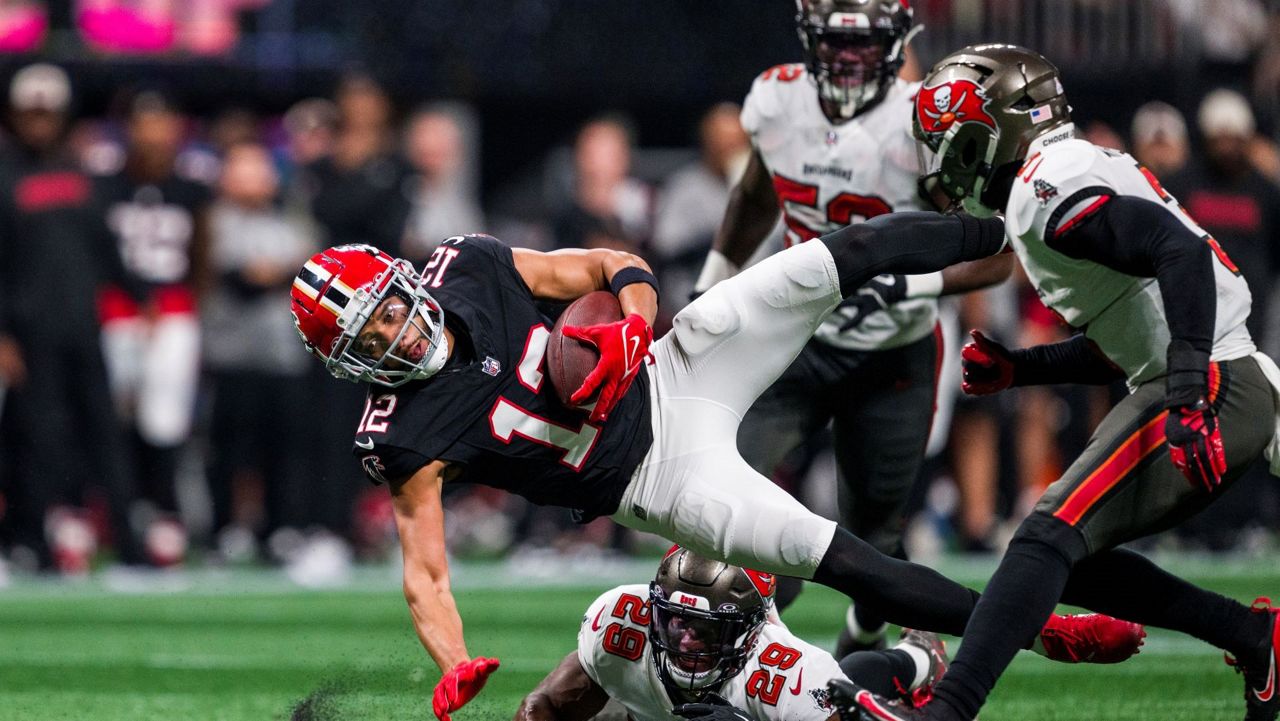 Atlanta Falcons wide receiver KhaDarel Hodge (12) is upended by Tampa Bay Buccaneers safety Christian Izien (29) during the first half of an NFL football game, Thursday, Oct. 3, 2024, in Atlanta. The Falcons defeated the Buccaneers 36-30 in overtime. (AP Photo/Danny Karnik)