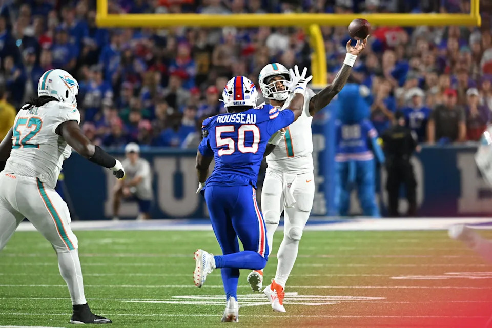 Sep 18, 2025; Orchard Park, New York, USA; Miami Dolphins quarterback Tua Tagovailoa (1) passes against Buffalo Bills defensive end Greg Rousseau (50) in the second quarter at Highmark Stadium. Mandatory Credit: Mark Konezny-Imagn Images