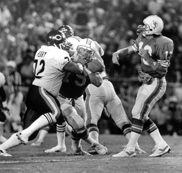 The Bears' William "Refrigerator" Perry encounters a roadblock, tackle Jon Giesler, on the path to Miami quarterback Dan Marino on Dec. 2, 1985. The Bears' rookie was shut out on defense by the Dolphins. (Ed Wagner Jr./Chicago Tribune)