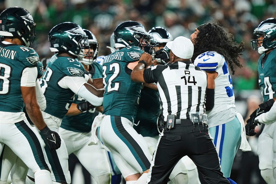 A referee separates Philadelphia Eagles and Dallas Cowboys players during a scuffle.