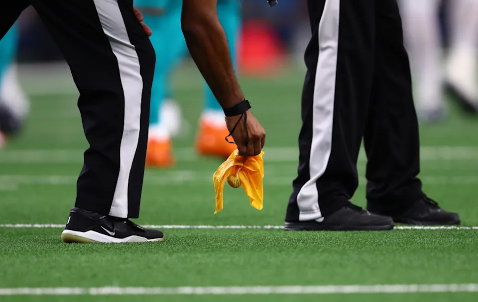Sep 22, 2019; Arlington, TX, USA; A referee picks up a penalty flag during the game with the Dallas Cowboys playing against the Miami Dolphins at AT&T Stadium. Mandatory Credit: Matthew Emmons-USA TODAY Sports© Matthew Emmons-Imagn Images