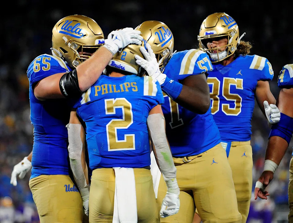 Sep 4, 2021; Pasadena, California, USA; UCLA Bruins wide receiver Kyle Philips (2) celebrates with offensive lineman Paul Grattan (65) offensive lineman Jon Gaines II (57) and tight end Greg Dulcich (85) his touchdown scored against the Louisiana State Tigers during the second half the at the Rose Bowl. Mandatory Credit: Gary A. Vasquez-USA TODAY Sports