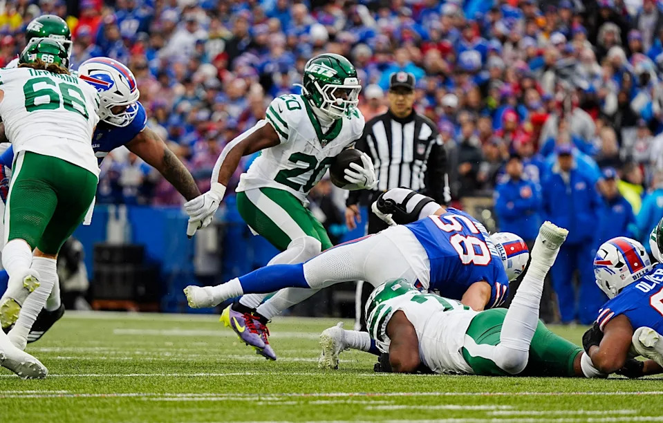 New York Jets running back Breece Hall (20) avoids several Bills players for a gain of several yards during first half action at the Bills home game against the New York Jets at Highmark Stadium in Orchard Park on Dec. 29, 2024.