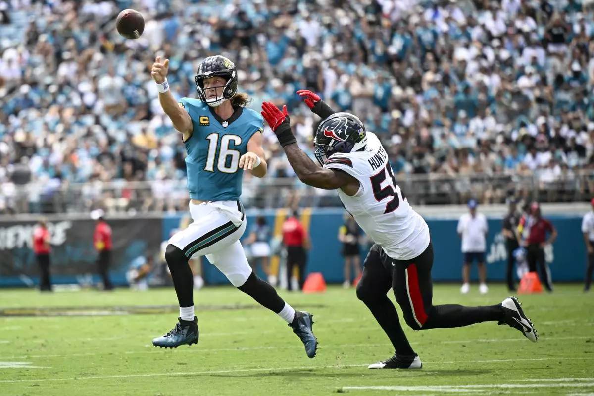 Jacksonville Jaguars quarterback Trevor Lawrence (16) attempts a pass in front of Houston Texans defensive end Danielle Hunter during the first half of an NFL football game Sunday, Sept. 21, 2025, in Jacksonville, Fla. (AP Photo/Phelan M. Ebenhack)