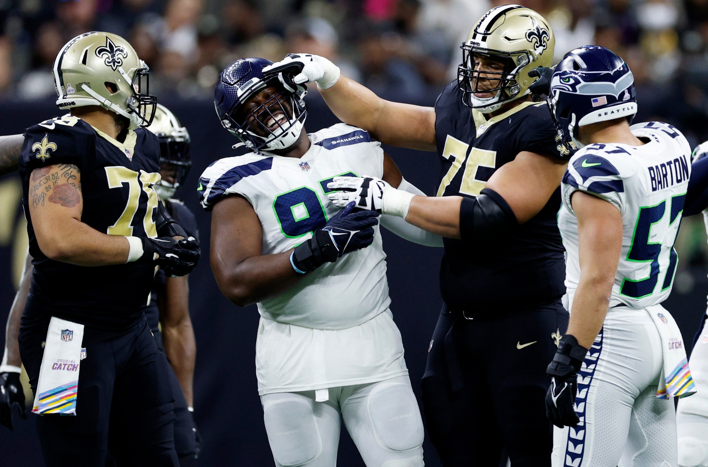 NEW ORLEANS, LOUISIANA - OCTOBER 09: Shelby Harris #93 of the Seattle Seahawks and Andrus Peat #75 of the New Orleans Saints joke around after a false start during the second half of the game at Caesars Superdome on October 09, 2022 in New Orleans, Louisiana. (Photo by Chris Graythen/Getty Images)