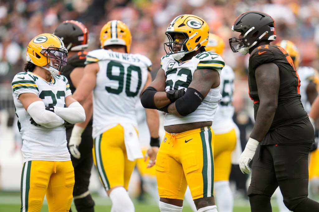 Green Bay Packers players and a Cleveland Browns player on the field.