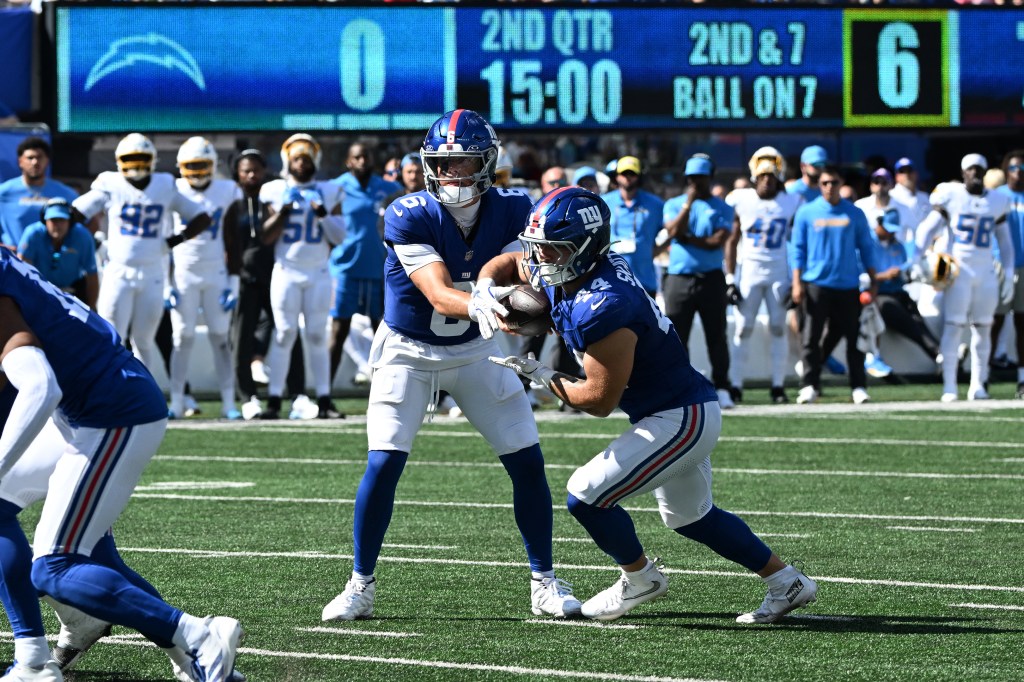 Cam Skattebo (R.) takes a handoff from Jaxson Dart during the Giants-Chargers game on Sept. 28, 2025. 