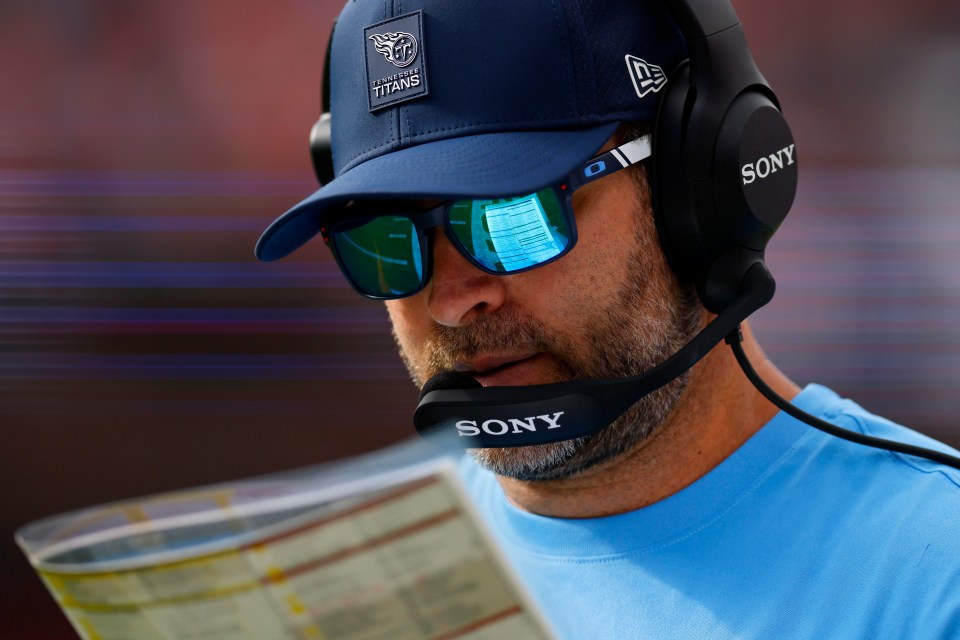 Brian Callahan, Tennessee Titans head coach, reviewing a playbook.