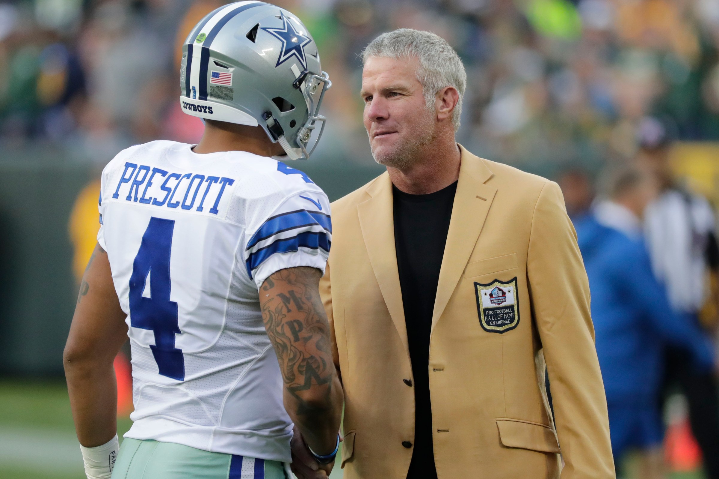 Oct 16, 2016; Green Bay, WI, USA; Dallas Cowboys quarterback Dak Prescott (4) greets Former Green Day Packers quarterback Brett Favre (R) after being introduced to the Hall of Fame at Lambeau Field. Mandatory Credit: Jim Matthews/Wisconsin via Imagn Images