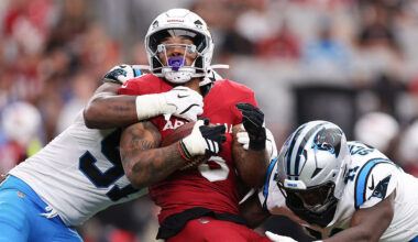 Patrick Jones II #91 and Nic Scourton #11 of the Carolina Panthers tackle James Conner #6 of the Ar...