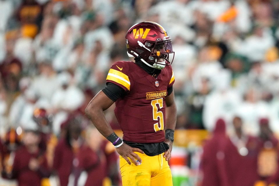Jayden Daniels #5 of the Washington Commanders reacts after being hit.