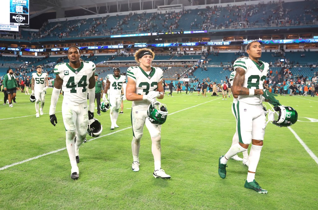 New York Jets players Jamien Sherwood (#44), Isaiah Davis (#32), and Josh Reynolds (#83) walking off the field after losing to the Miami Dolphins.