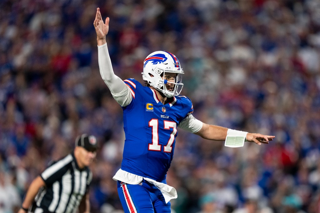 Buffalo Bills quarterback Josh Allen in his blue uniform with number 17, with his right arm raised.