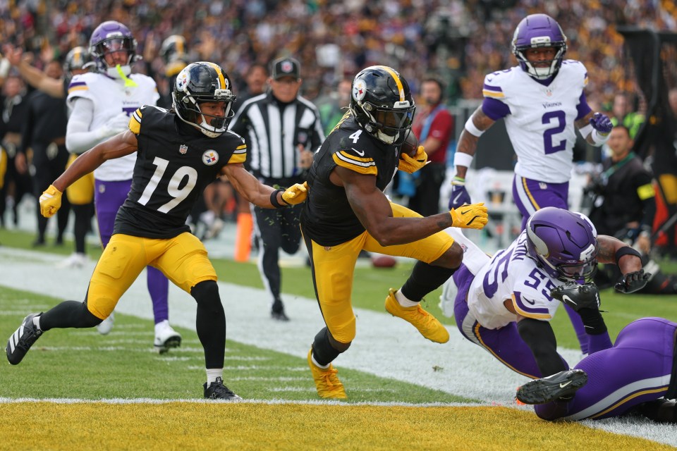 Pittsburgh Steelers wide receiver Dk Metcalf (4) runs the ball to score a touchdown as a Minnesota Vikings player (55) attempts a tackle.