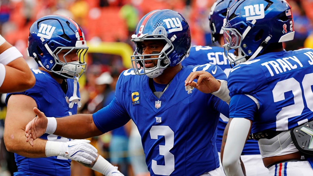 Russell Wilson high-fives teammates before game