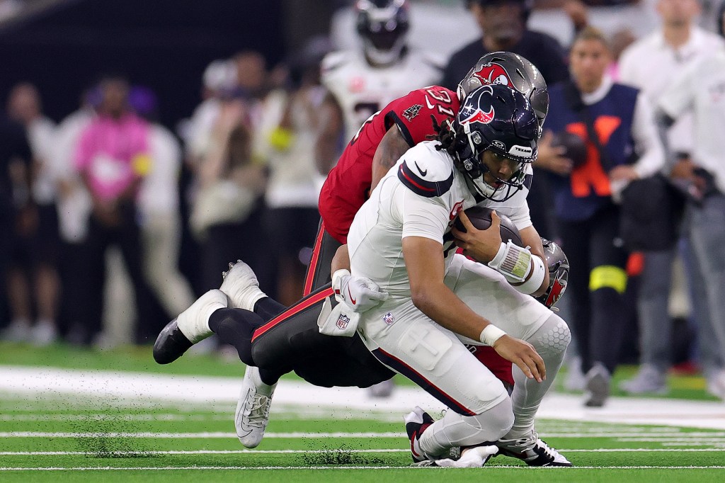 Houston Texans player being tackled by a Tampa Bay Buccaneers player.