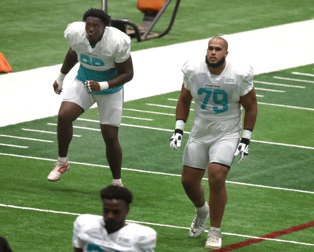 Miami Dolphins offensive tackle Braeden Daniels and offensive lineman Larry...