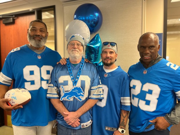 Gathering for a photo and chat during Wednesday's tailgate party at Henry Ford Health are former Detroit Lions James Cribbs, left, Charles Christien Sr., Charles Christien Jr. and former Detroit Lions Maurice Harvey. GINA JOSEPH - THE MACOMB DAILY