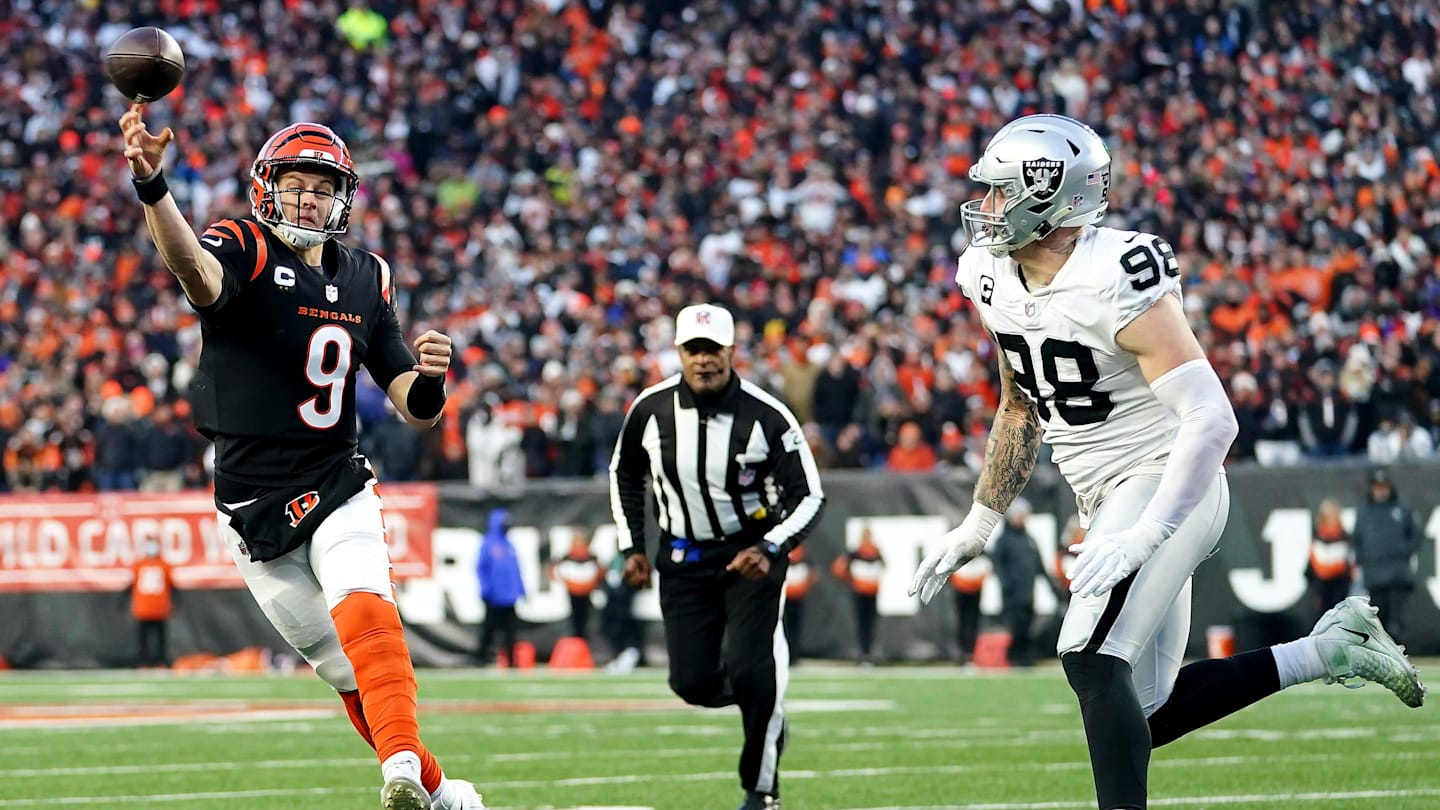 Jan 15, 2022; Cincinnati, OH, USA;  Cincinnati Bengals quarterback Joe Burrow (9) throws as Las Vegas Raiders defensive end Maxx Crosby (98) pressures in the second quarter during an NFL AFC wild-card playoff game, Saturday, Jan. 15, 2022, at Paul Brown Stadium in Cincinnati. Mandatory Credit: Kareem Elgazzar-Imagn Images