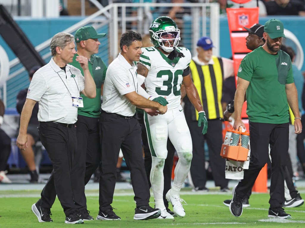 Cornerback Michael Carter II #30 of the New York Jets is taken off the field by trainers during the second quarter.