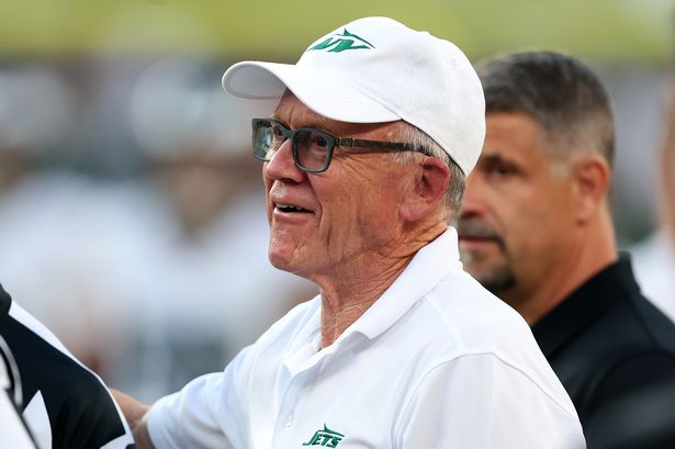 Jets team owner Woody Johnson stands on the field