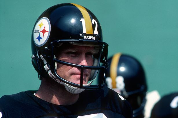 Quarterback Terry Bradshaw #12 of the Pittsburgh Steelers looks on from the sideline before a game against the New England Patriots at Three Rivers Stadium on September 27, 1981 in Pittsburgh, Pennsylvania.  The Steelers defeated the Patriots 27-21