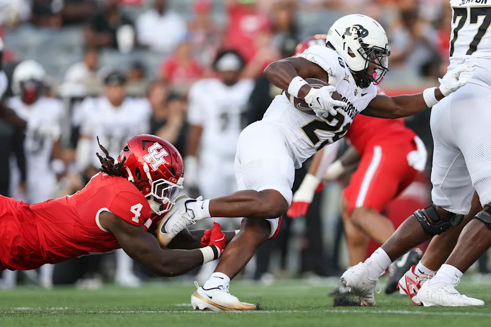 Sep 12, 2025; Houston, Texas, USA; Colorado Buffaloes running back Micah Welch (29) runs with the ball as Houston Cougars linebacker Brandon Mack II (4) attempts to make a tackle during the first quarter at TDECU Stadium. Mandatory Credit: Troy Taormina-Imagn Images