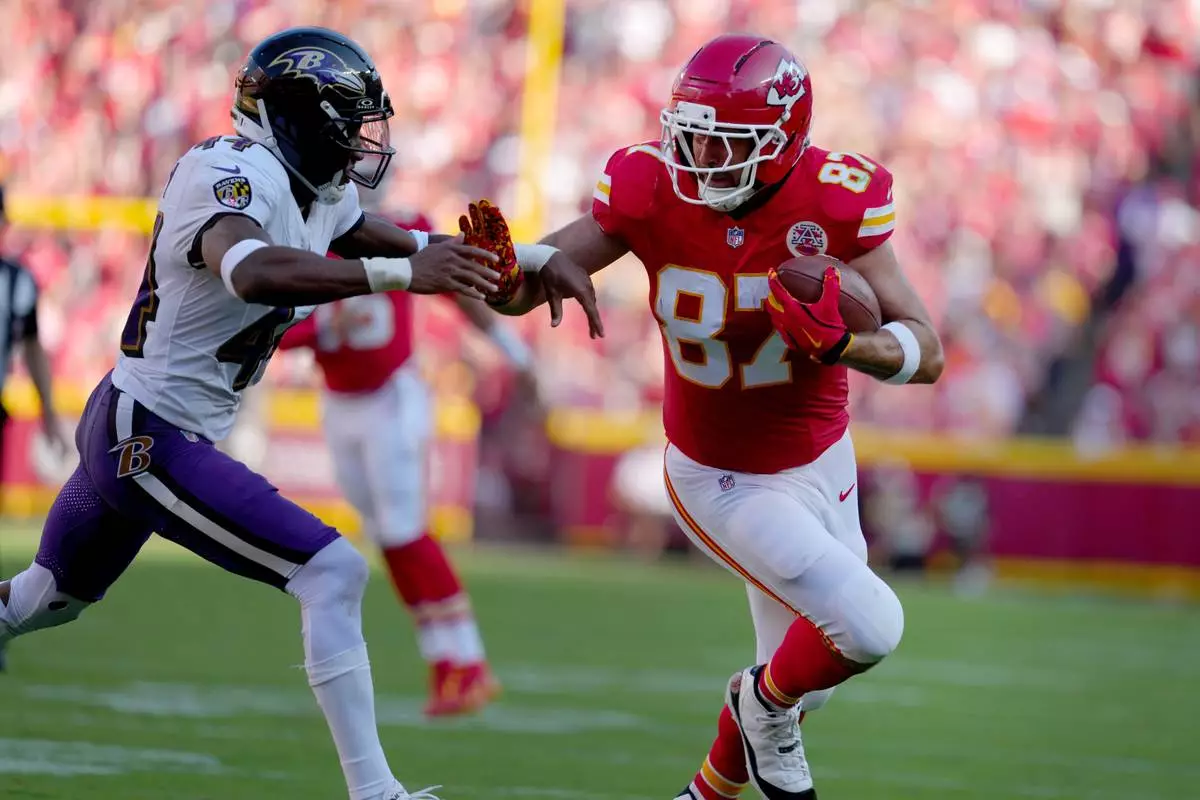 Kansas City Chiefs tight end Travis Kelce (87) runs with the ball as Baltimore Ravens cornerback Marlon Humphrey (44) defends during the first half of an NFL football game Sunday, Sept. 28, 2025, in Kansas City, Mo. (AP Photo/Ed Zurga)