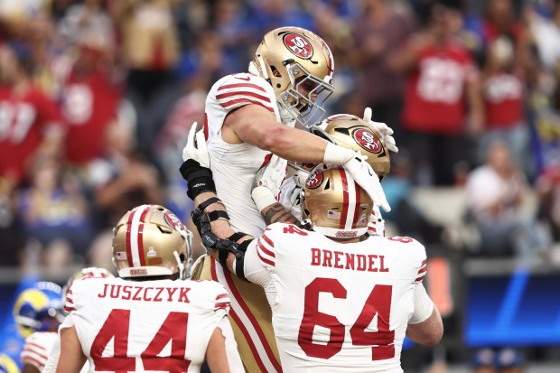 San Francisco 49ers tight end Jake Tonges, top, is congratulated by teammates after scoring against the Los Angeles Rams during the first half of an NFL football game, Thursday, Oct. 2, 2025, in Inglewood, Calif. (AP Photo/Jessie Alcheh)