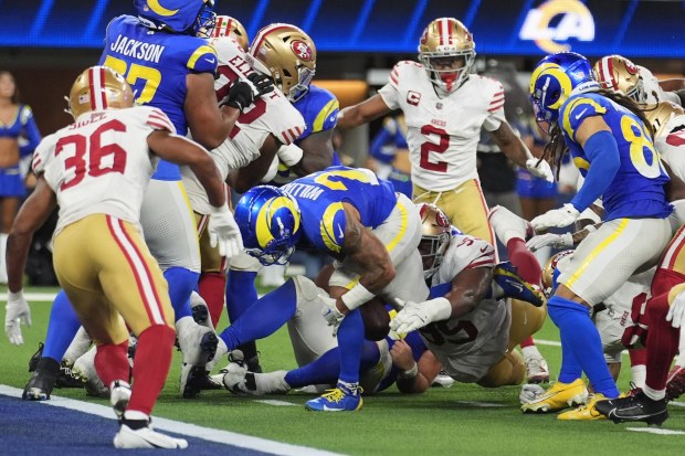 Los Angeles Rams running back Kyren Williams, middle, fumbles the ball, which was recovered by San Francisco 49ers defensive tackle Alfred Collins, bottom middle right, during the second half of an NFL football game, Thursday, Oct. 2, 2025, in Inglewood, Calif. (AP Photo/Marcio Jose Sanchez)