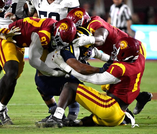 Defensive end Kameryn Crawford #1 of the USC Trojans tackles...