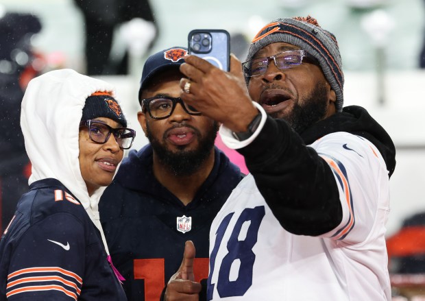 Fans take pictures before a Bears-Commanders game at Northwest Stadium...