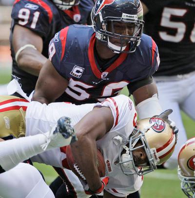 San Francisco 49ers wide receiver Michael Crabtree (15) is tackled with help from Houston Texans linebacker DeMeco Ryans (59) in the first quarter of a NFL football game Sunday, Oct. 25, 2009 in Houston. (AP Photo/David J. Phillip)