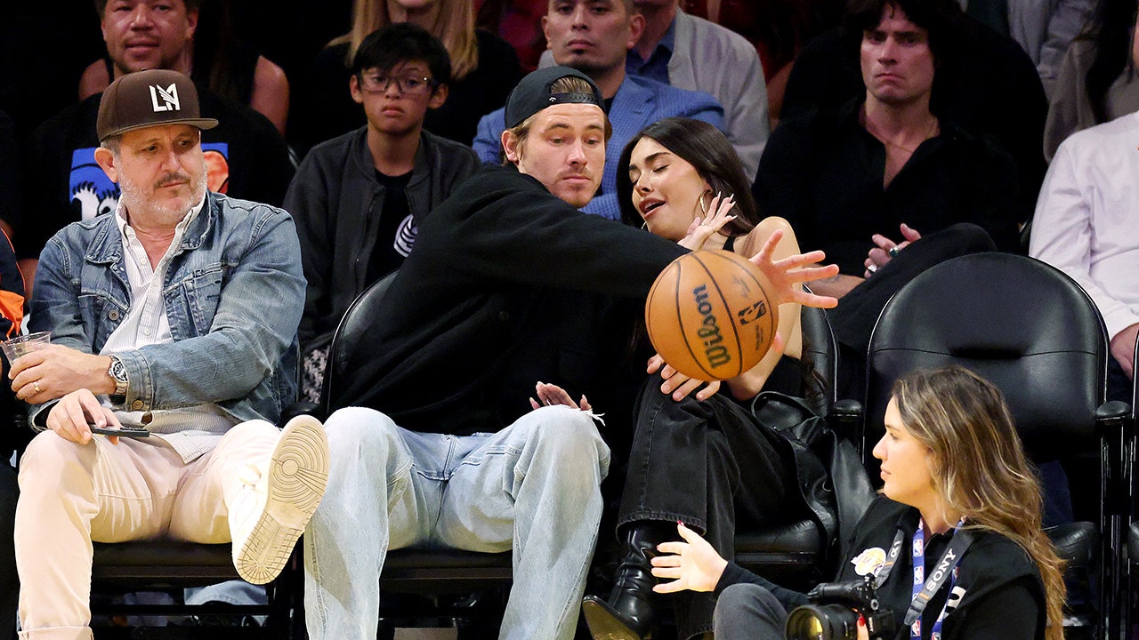 Chargers' Justin Herbert protects Madison Beer from basketball at Lakers game
