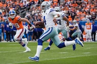 Dallas Cowboys quarterback Dak Prescott (4) scrambles away from the Denver Broncos defense...