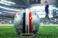A Dallas Cowboys helmet with a red stripe in recognition of  Salute to Service honoring US...
