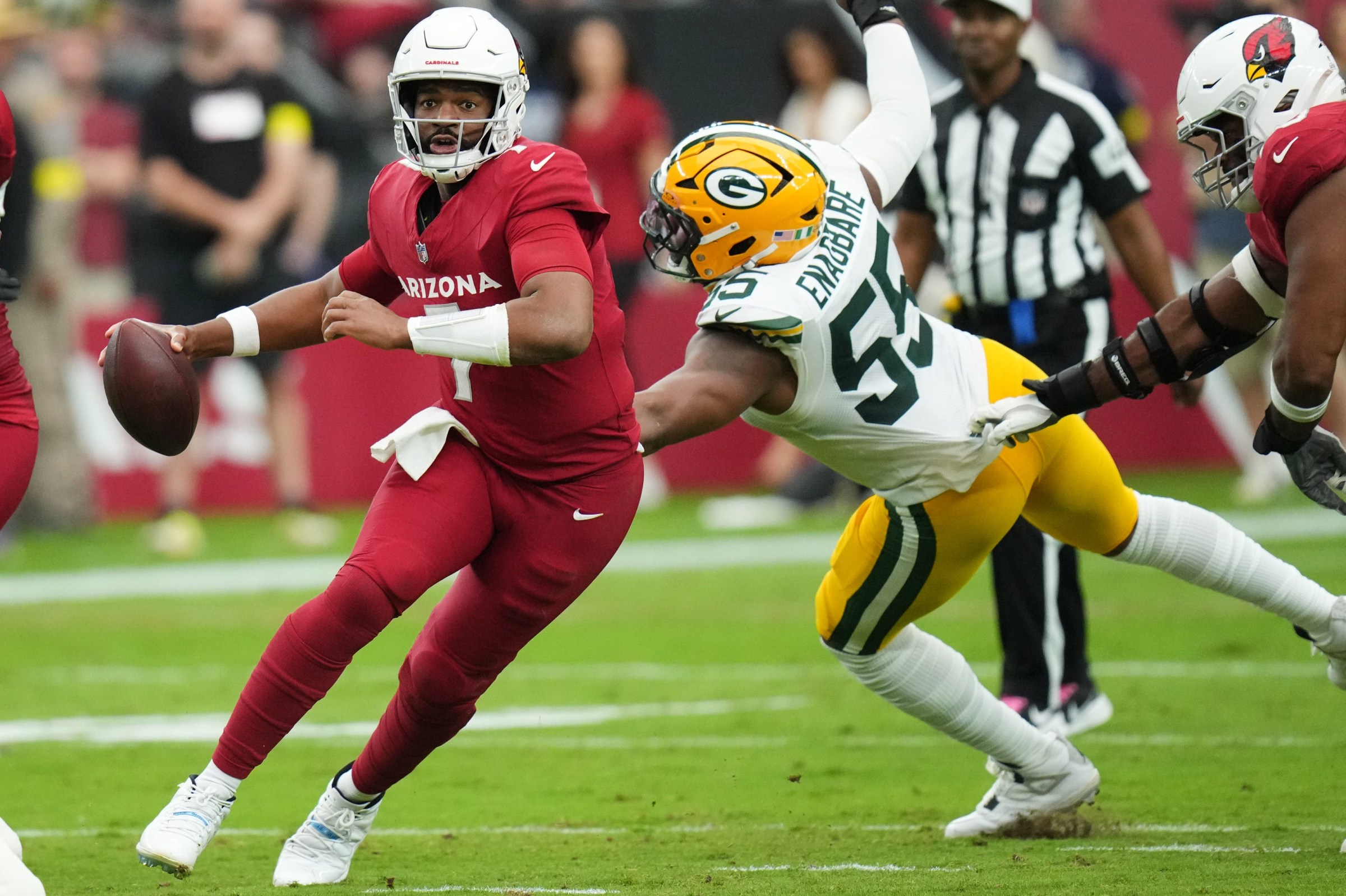 Arizona Cardinals quarterback Jacoby Brissett (7) scrambles past Green Bay Packers defensive lineman Kingsley Enagbare (55) at State Farm Stadium in Glendale on Oct. 19, 2025.