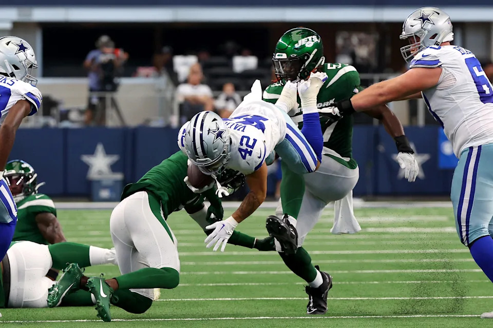 ARLINGTON, TEXAS - SEPTEMBER 17: Deuce Vaughn #42 of the Dallas Cowboys is upended by Sauce Gardner #1 of the New York Jets at AT&T Stadium on September 17, 2023 in Arlington, Texas. (Photo by Richard Rodriguez/Getty Images)