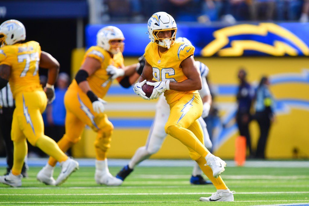 Los Angeles Chargers player in yellow uniform holding a football during a game against the Indianapolis Colts.