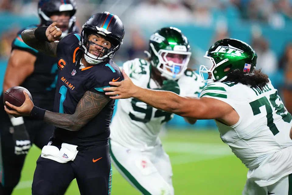 Sep 29, 2025; Miami Gardens, Florida, USA; Miami Dolphins quarterback Tua Tagovailoa (1) avoids the tackle from New York Jets defensive tackle Jay Tufele (78) during the second half at Hard Rock Stadium. Mandatory Credit: Rich Storry-Imagn Images