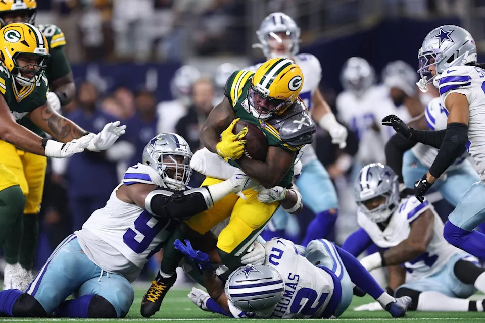 Green Bay Packers ‘Josh Jacobs is tackled by Osa Odighizuwa and Juanyeh Thomas of the Dallas Cowboys during overtime on Sunday (Sam Hodde/Getty Images)