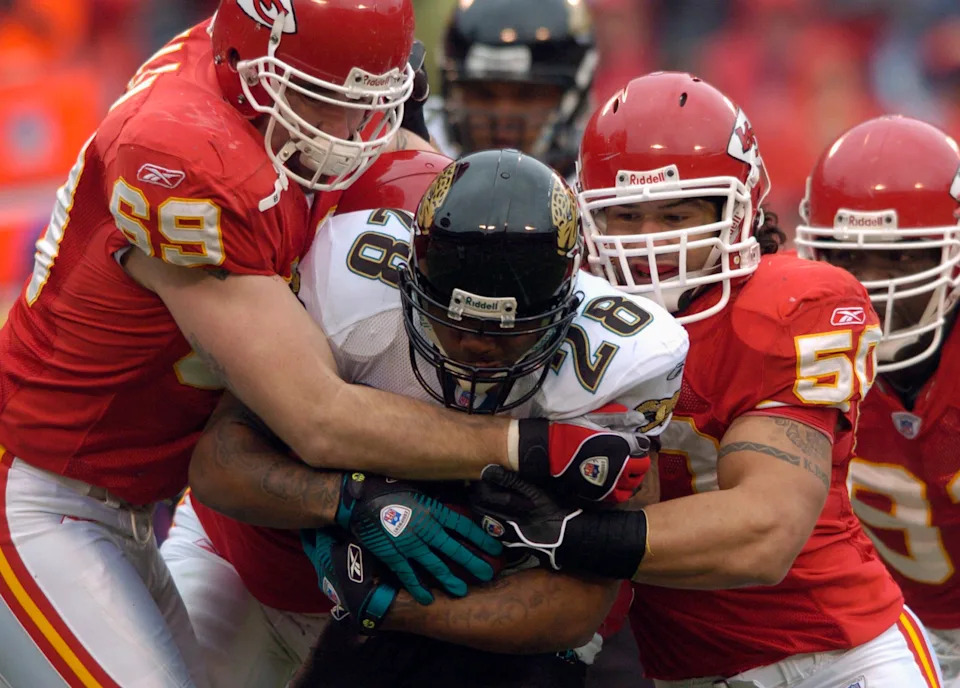 Kansas City Chiefs defensive end Jared Allen (L) and linebacker Kawika Mitchell (R) tie up Jacksonville Jaguars running back Fred Taylor (C) in the first quarter during their NFL football game at Arrowhead Stadium in Kansas City, Missouri, December 31, 2006. REUTERS/Dave Kaup (UNITED STATES)