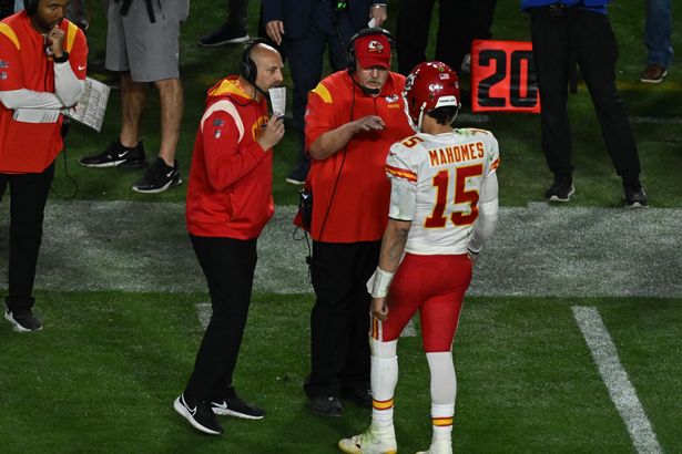 Kansas City Chiefs quarterback Patrick Mahomes speaks to his coaching staff on the sideline during an NFL game