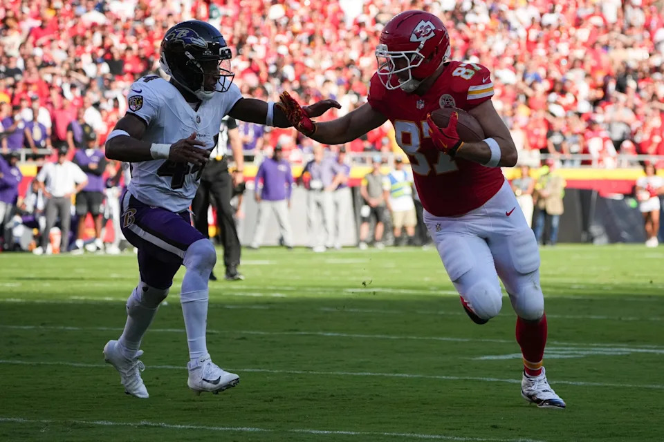 Sep 28, 2025; Kansas City, Missouri, USA; Kansas City Chiefs tight end Travis Kelce (87) runs with the ball as Baltimore Ravens cornerback Marlon Humphrey (44) defends during the second quarter at GEHA Field at Arrowhead Stadium. Mandatory Credit: Denny Medley-Imagn Images