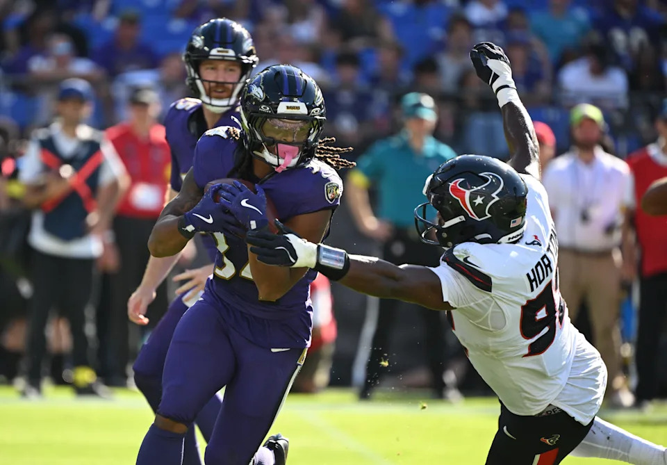 Oct 5, 2025; Baltimore, Maryland, USA; Baltimore Ravens running back Keaton Mitchell (34) runs for a gain past Houston Texans defensive end Dylan Horton (92) during the fourth quarter at M&T Bank Stadium. Mandatory Credit: Rafael Suanes-Imagn Images